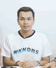 a man wearing a white t-shirt that says wkndrs