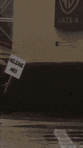 a sign for gate 4 hangs on a wall