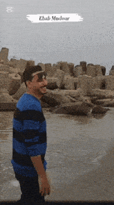 a man standing on a beach with the name ehab mndour written on the bottom