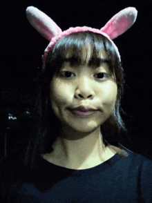 a woman wearing bunny ears looks at the camera