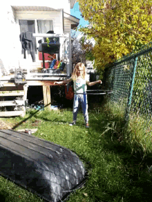 a person laying in the grass with a fence in the background and a boat in the foreground