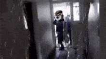 a person is walking down a hallway with a dog in the background .