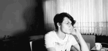 a black and white photo of a man wearing glasses and a white shirt