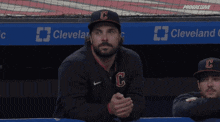 two baseball players are hugging each other in a dugout with a banner that says grand clinic
