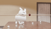 a white stuffed animal is laying on a table