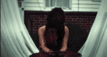 a woman in a red dress is sitting on a table covered in blood