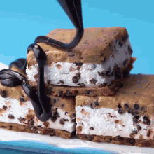 a stack of cookie dough ice cream sandwiches with chocolate being poured on top