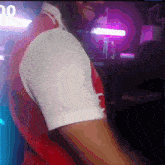 a man in a red and white shirt is dancing in a dark room with the number 00 in the background
