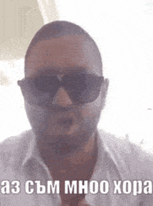 a man wearing sunglasses and a white shirt is making a face .