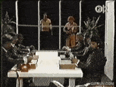 a group of people are sitting around a table with a gifrun.com logo on the bottom
