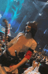 a man in a costume with a cat tail is dancing in front of a crowd