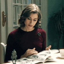 a woman with a brooch on her neck is reading a magazine