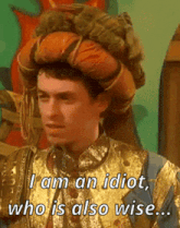 a man in a gold and blue costume says i am an idiot who is also wise