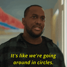 a man in a plaid shirt is saying it 's like we 're going around in circles
