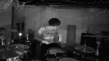 a man playing drums in a room with a shirt that says ' almost infinite '