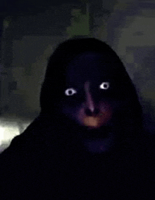 a close up of a person 's face in the dark with bright eyes .