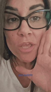 a woman wearing glasses holds her hand to her face and says you suck