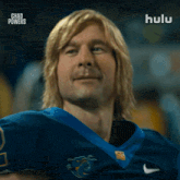 a man with blonde hair is wearing a blue jersey that says chad powers on it