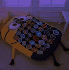 a bed made to look like a minion with a blanket filled with spinning tops on it .