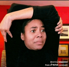 a woman is stretching her arm while wearing a black shirt