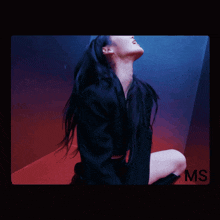 a woman is kneeling down in a dark room with the word ms on the bottom right