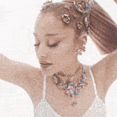 a woman wearing a necklace and earrings has a ponytail