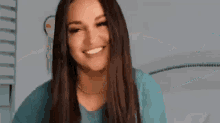 a woman with long hair is making a heart shape with her hands .