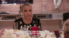 a woman sitting at a table with real housewives written on the bottom
