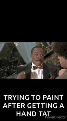 a man in a tuxedo with a red bow tie is giving a thumbs up