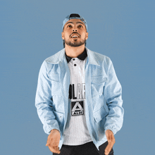 a man wearing a light blue jacket and a white shirt with the word aldi on it