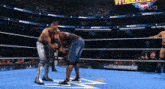 two men are wrestling in a wrestling ring with a sign that says virgin