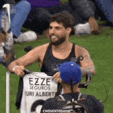 a man is holding up a jersey that says ezze seguros uri alberto