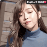 a close up of a woman 's face with rhythm written on the corner