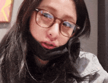 a woman wearing glasses and a black face mask