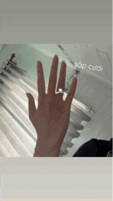 a woman 's hand is shown with a ring on it and the word sap cuoi below it