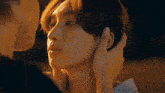 a close up of a man touching another man 's face with his hand ..