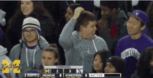 a group of people are watching a football game between michigan and nebraska