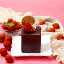 a chocolate cake with strawberries and a cookie that says ' jrd ' on it