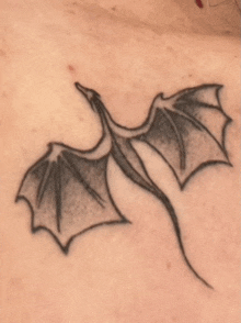 a close up of a dragon tattoo on a person 's chest