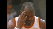 a close up of a basketball player covering his face with his hand