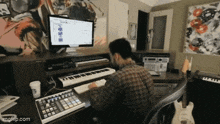 a man is sitting at a desk with a keyboard and a computer .