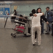 a woman hugging another woman in front of a sign that says " ro "