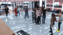 a group of people are dancing in a room with a keyboard .