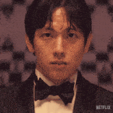 a man in a tuxedo and bow tie has a netflix logo on the bottom
