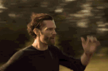 a man with a beard is running in a field