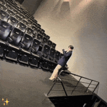 a man is standing on a staircase in front of a row of seats that say 3d on them