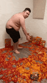 a man standing in a room covered in cheetos chips
