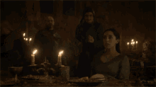 a woman is crying in front of a candle