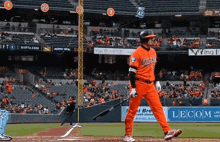 a baseball player wearing an orioles uniform stands on the field