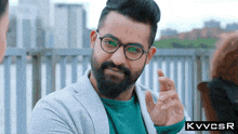 a man with glasses and a beard has the letters kvvcsr on the bottom